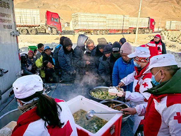 工作人員正在為村民分發(fā)熱氣騰騰的餐食。中國紅十字會總會供圖